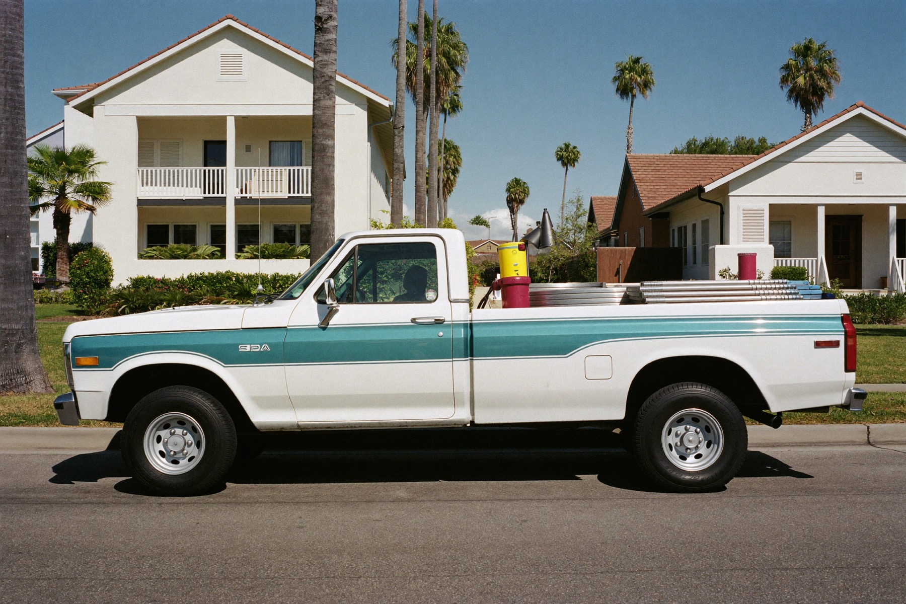 The Pelican Pool Care truck parked on a palm-lined Sarasota street